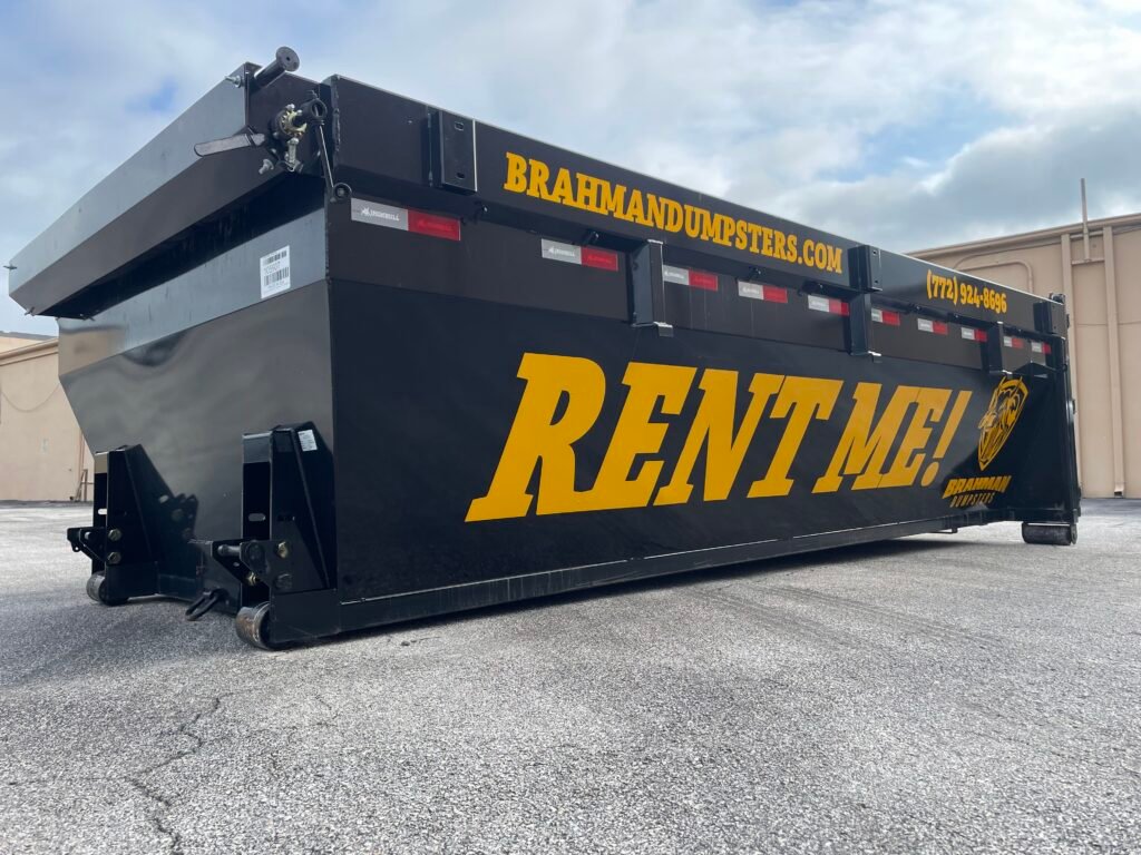 Dumpster Wrapped with Rent Me in Large Letters from a Front Angle View.